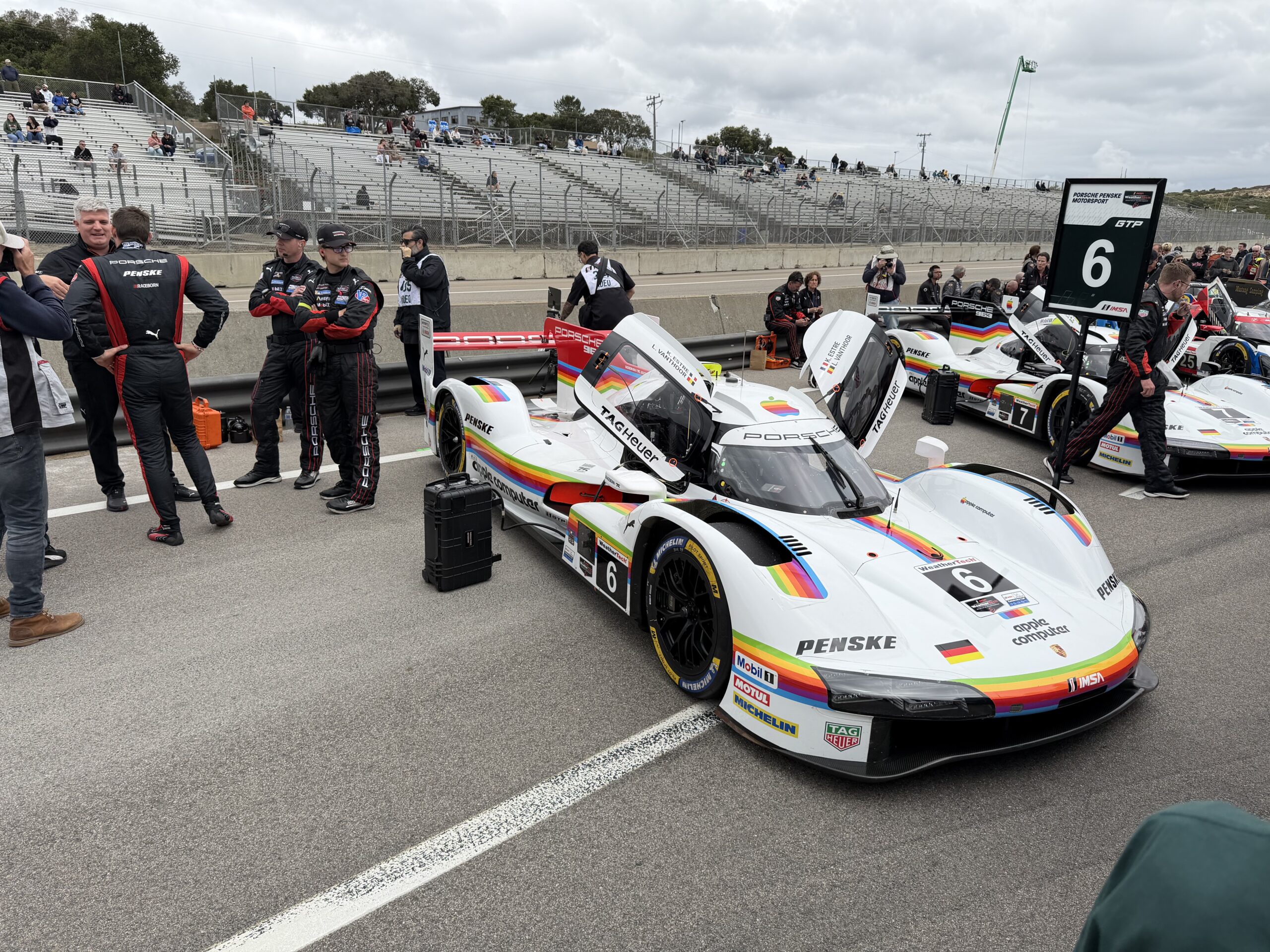 A Porsche race car surrounded by pit crew during pit walk at IMSA Laguna Seca